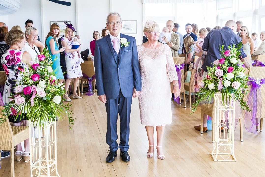 A mature bride and groom pose at the end of the aisle at their Ease wedding venue