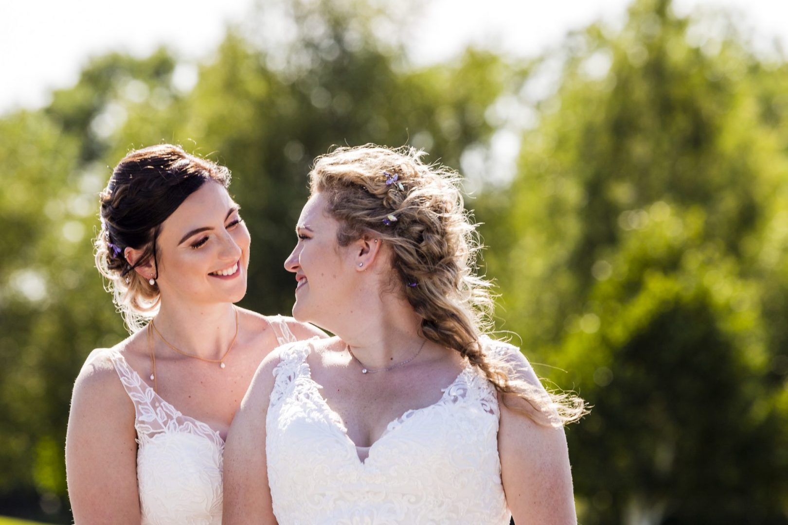 Two brides smiling and gazing into each other's eyes during their Rayleigh Club wedding