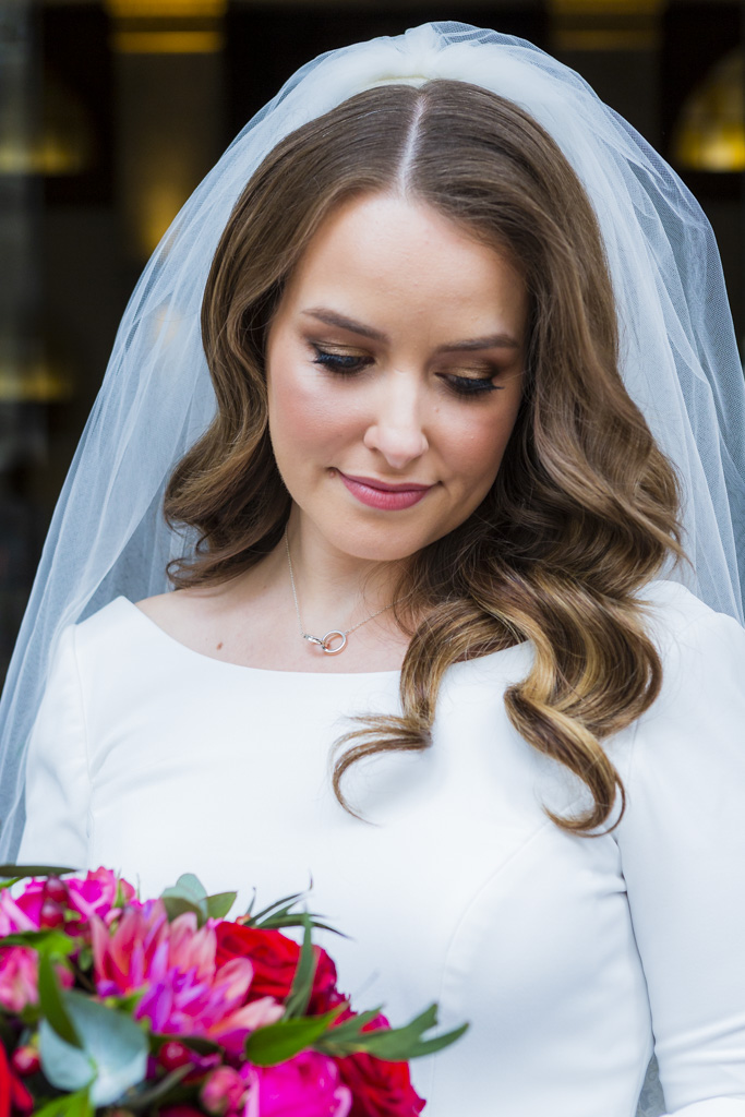 head and shoulders image of a bride in a veil looking down