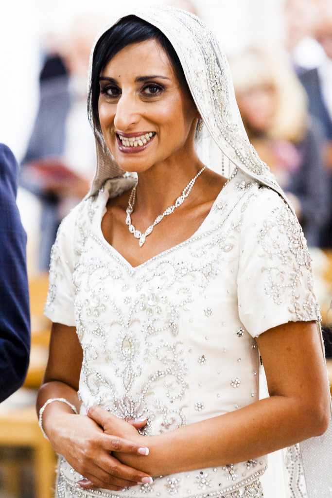 An asian bride smiles at the camera during her wedding ceremony