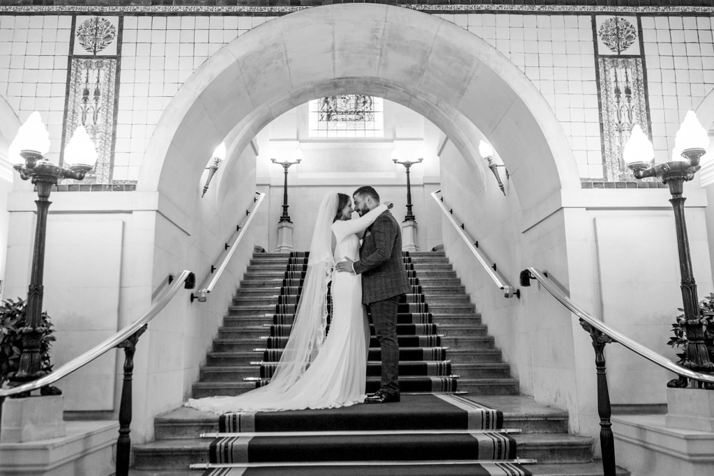 A couple posing on the stairs at their Essex wedding venue