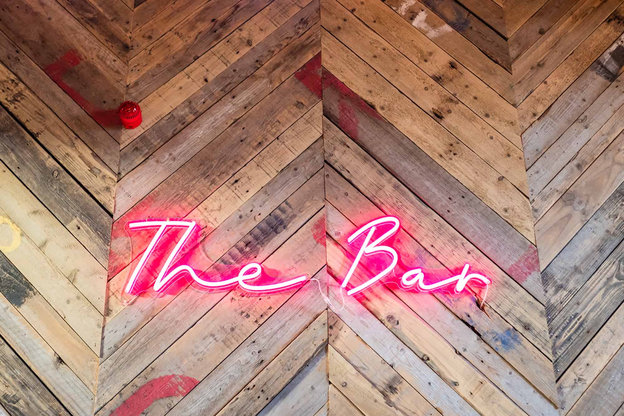 Pink neon "The Bar' sign at Canary Shed Essex