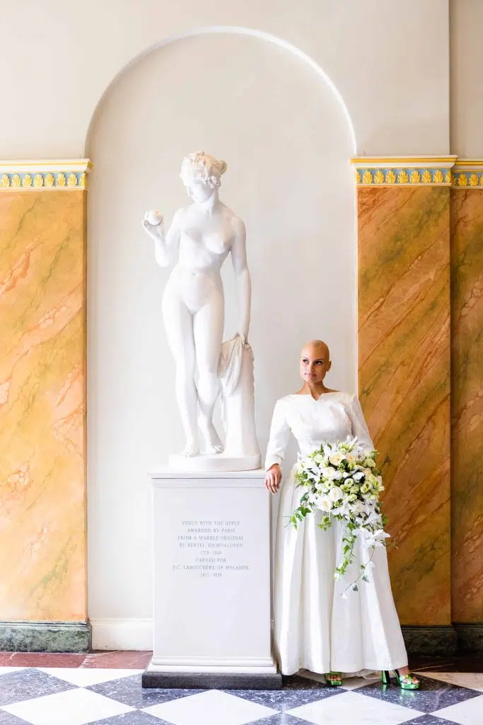A bride posing by the statue in the hallway of Hylands House