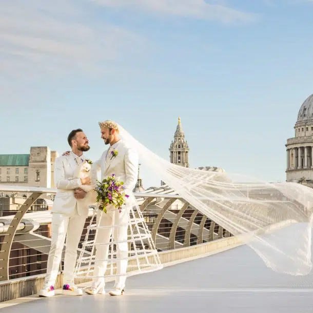 Two grooms in White - one with a veil in front of St Pauls Cathedral. Captured by London gas wedding photographer Ross Willsher