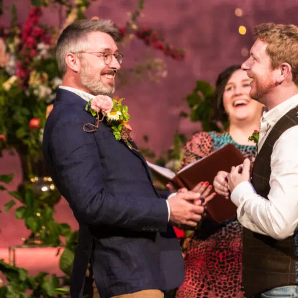 Gay wedding photographer London - two grooms laughing during their ceremony