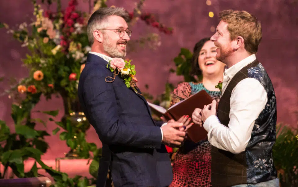 Gay wedding photographer London - two grooms laughing during their ceremony