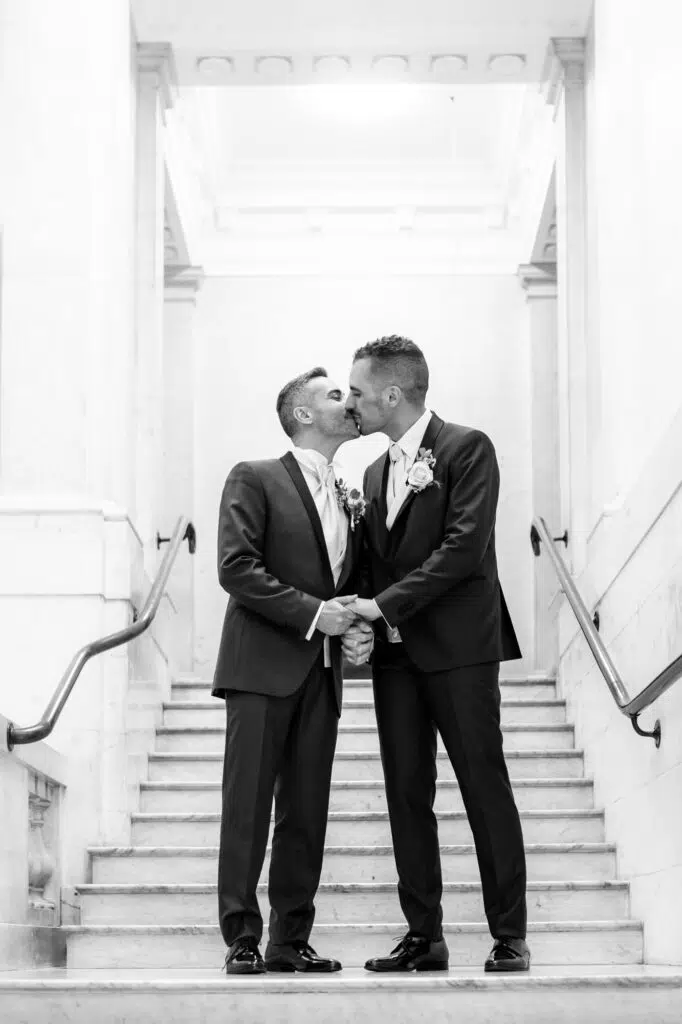 Two grooms kissing at Marylebone Town Hall. Captured by London gay wedding photographer Ross Willsher