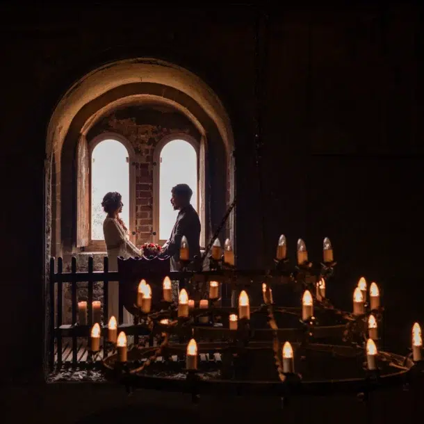 A silhouette of a couple at Hedingham Castle with the chandelier in front.