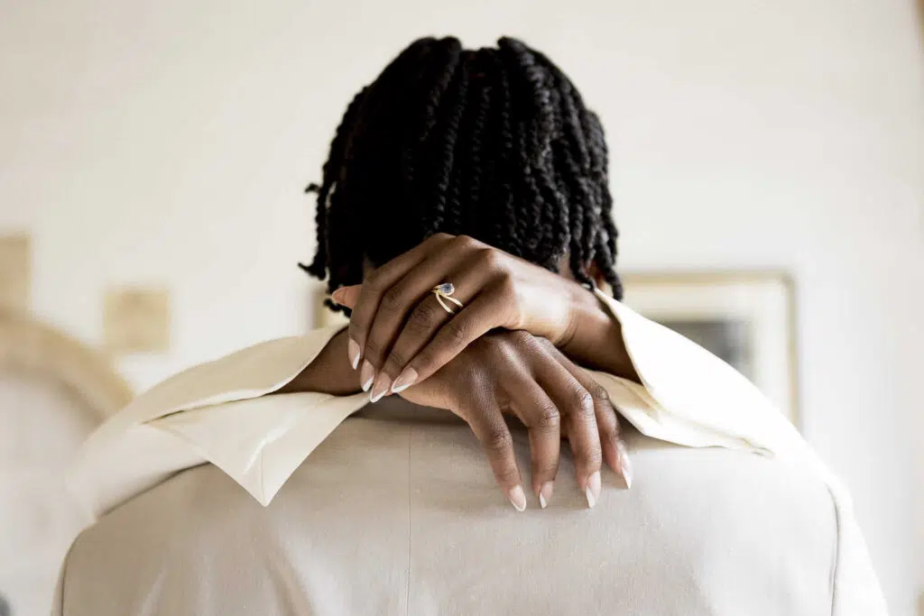 a birds hand around the back of the groom's neck during their wedding ceremony at butley priory