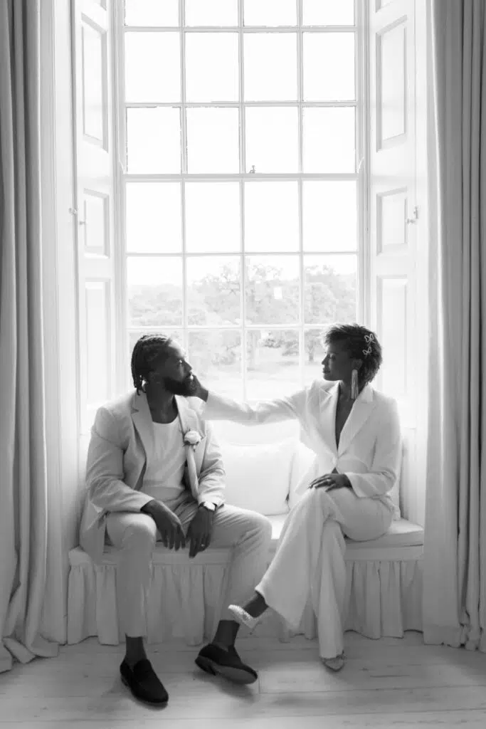 Couple portrait in the bedroom window at Butely Priory, Suffolk.