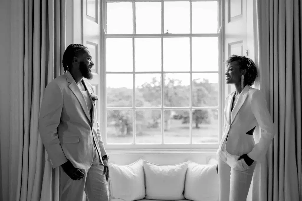 Bride and groom portrait in the bedroom window at Butely Priory, Suffolk.