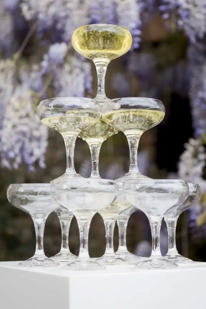 champagne tower in front of the wisteria at butler priory in wedding venue in Suffolk