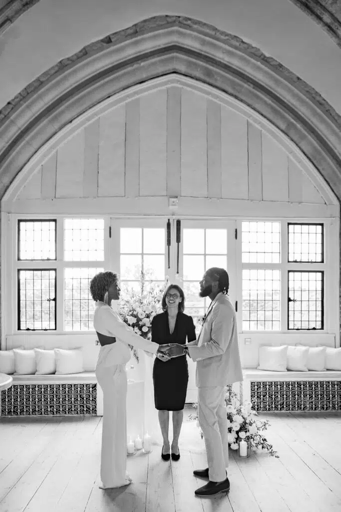 a couple and their wedding celebrant laughing during their ceremony at butler priory