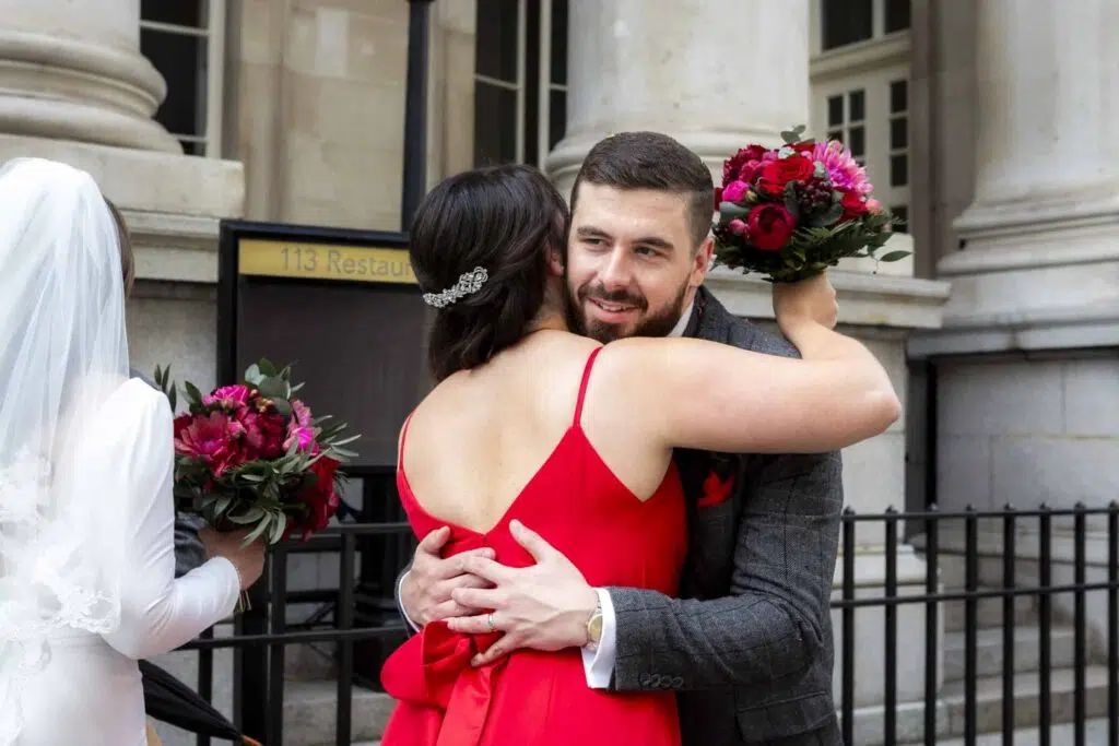 A groom hugging a bridesmaid during micro wedding in London