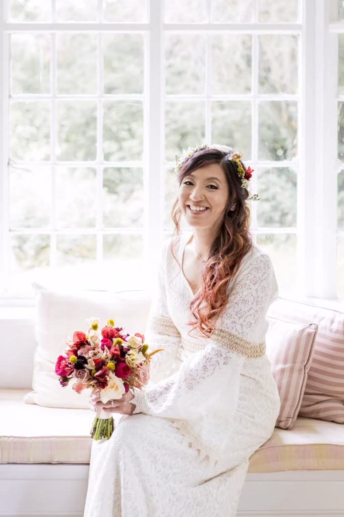 A bride poses for a photo during her wedding prep at Hedingham Castle in Essex