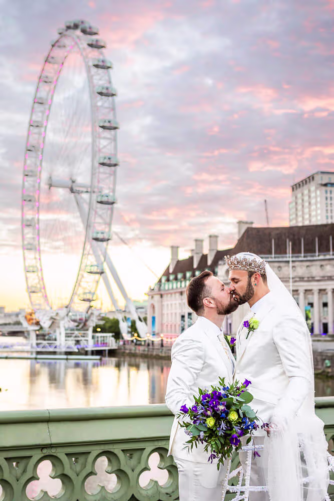 Two grooms kissing in front of the London Eye