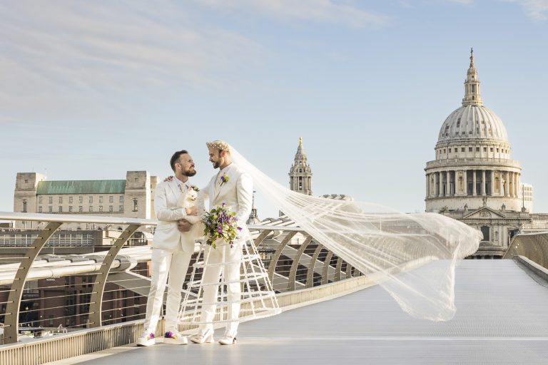 Pete and Will standing together on Millennium Bridge with St Paul’s Cathedral behind them, Will’s long veil flowing dramatically in the morning light.