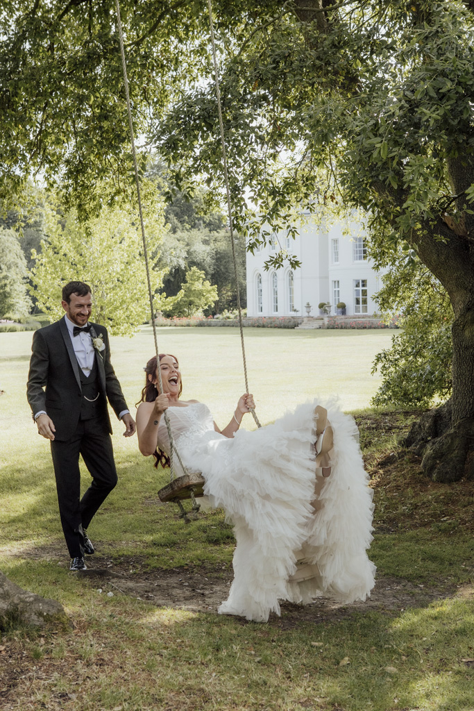 A bride and groom on the swing at Blake Hall wedding venue in Essex